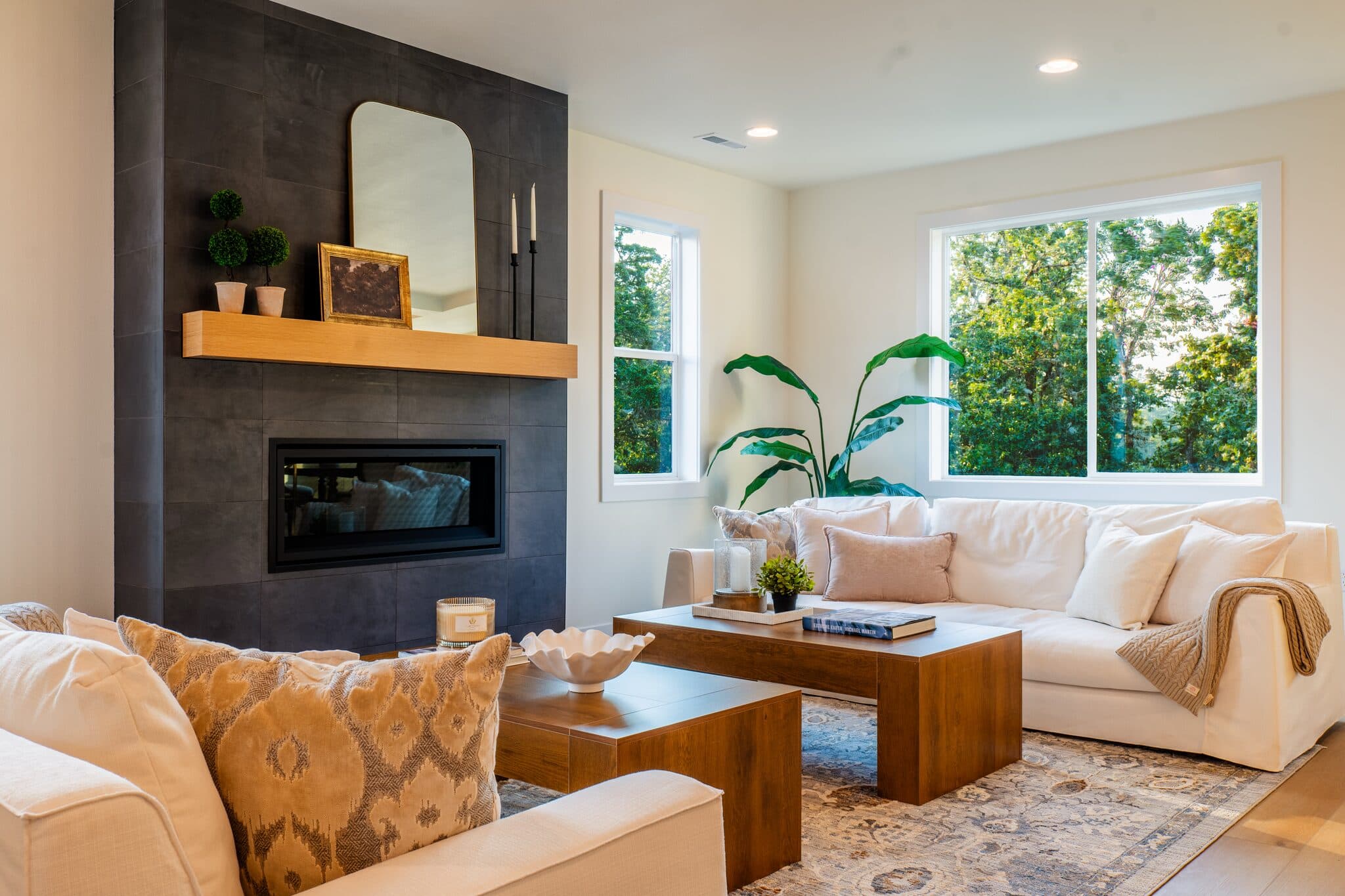 Living room with black tile fireplace and large windows — real estate photography by Hahn Media, Oregon